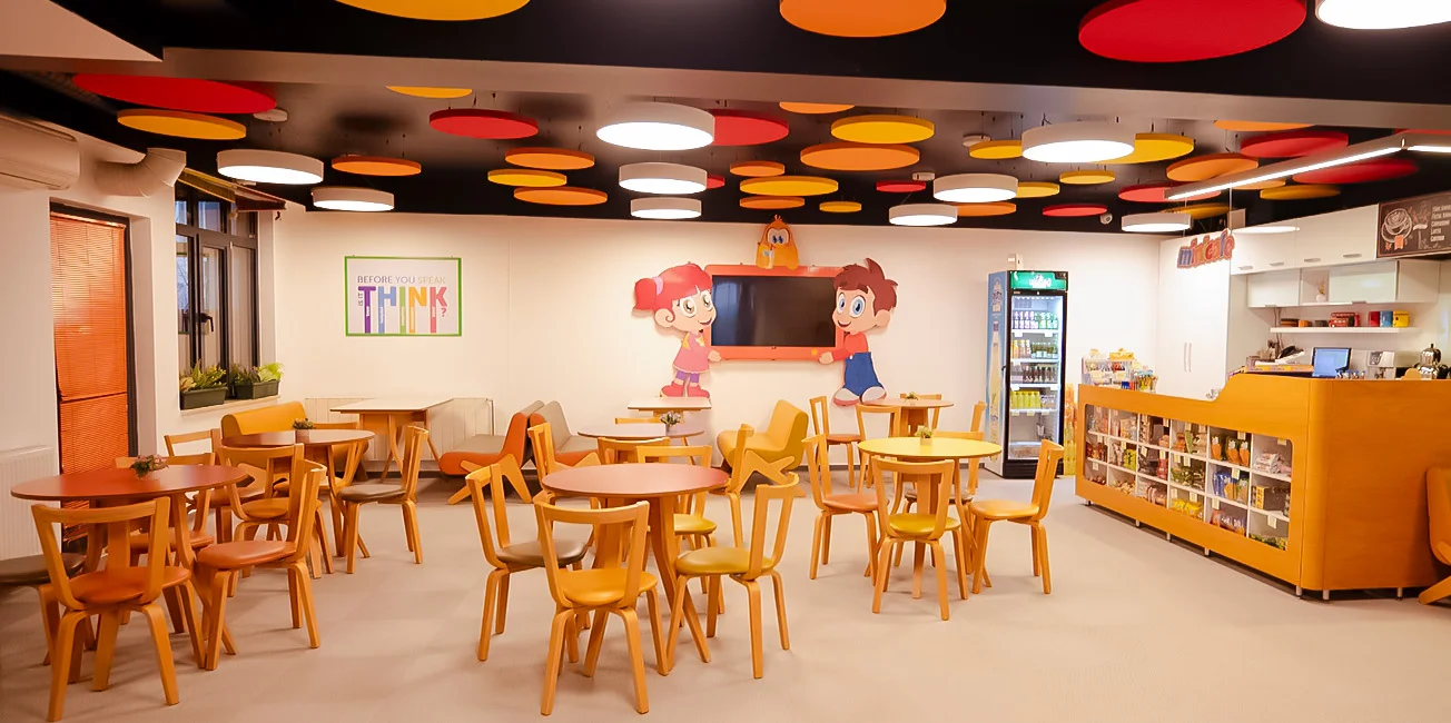 MiniCafe: tavanı renkli dairelerle süslü, ahşap masalar ve sandalyeler